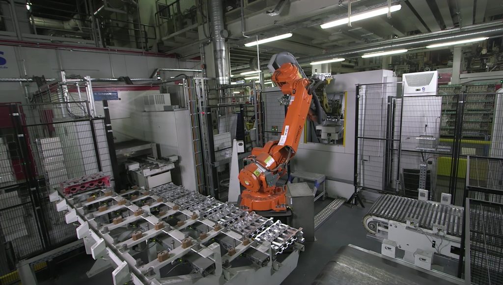 Ein Roboter nimmt einen Zylinderkopf auf, um den Computertomographen VoluMax direkt in der Linie damit zu best?cken. (Bild: Carl Zeiss Industrielle Messtechnik GmbH)
